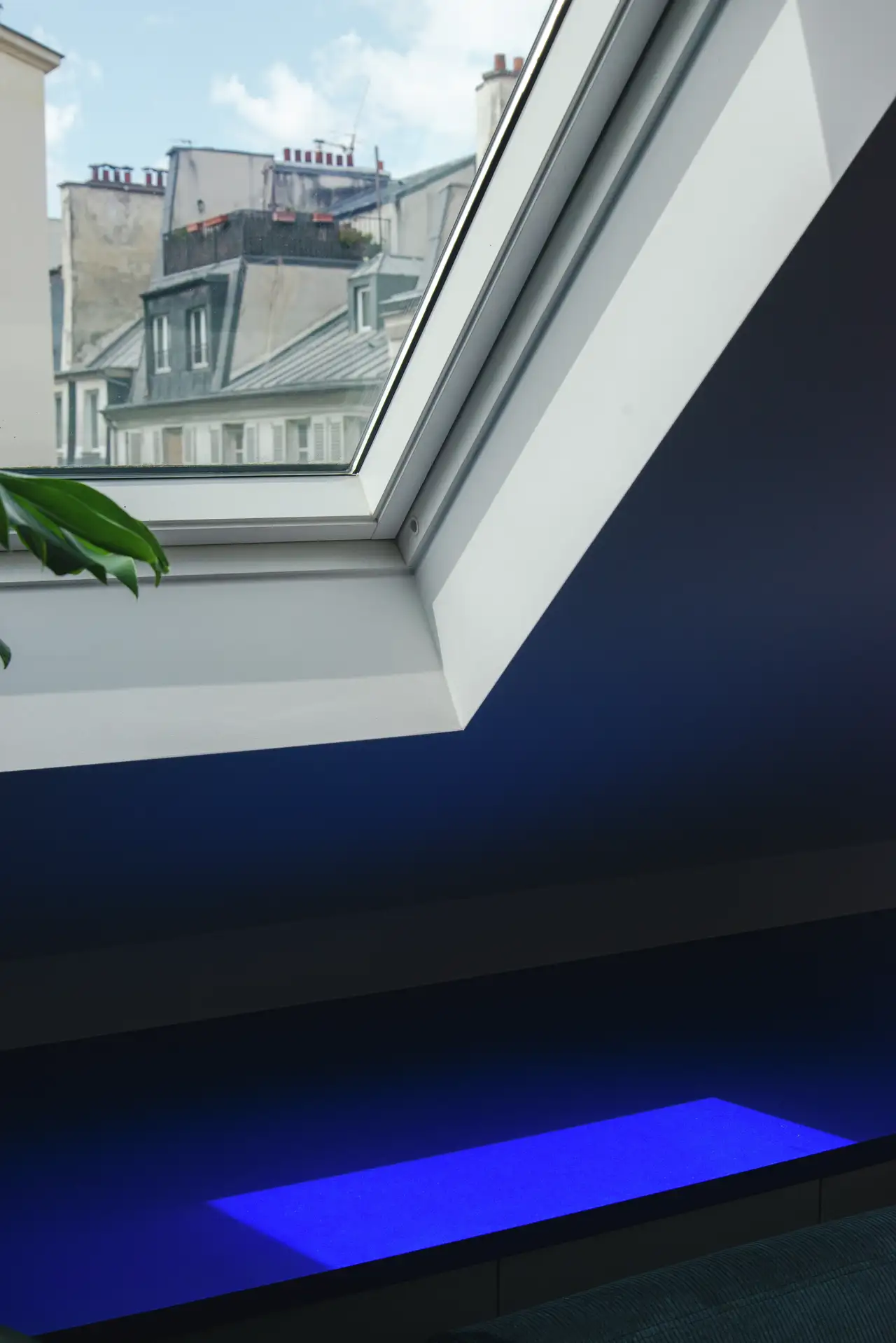 Skats uz jumta logu, kas ierāmē Parīzes panorāmu, ar zilu palodzi apakšā. | VELUX
