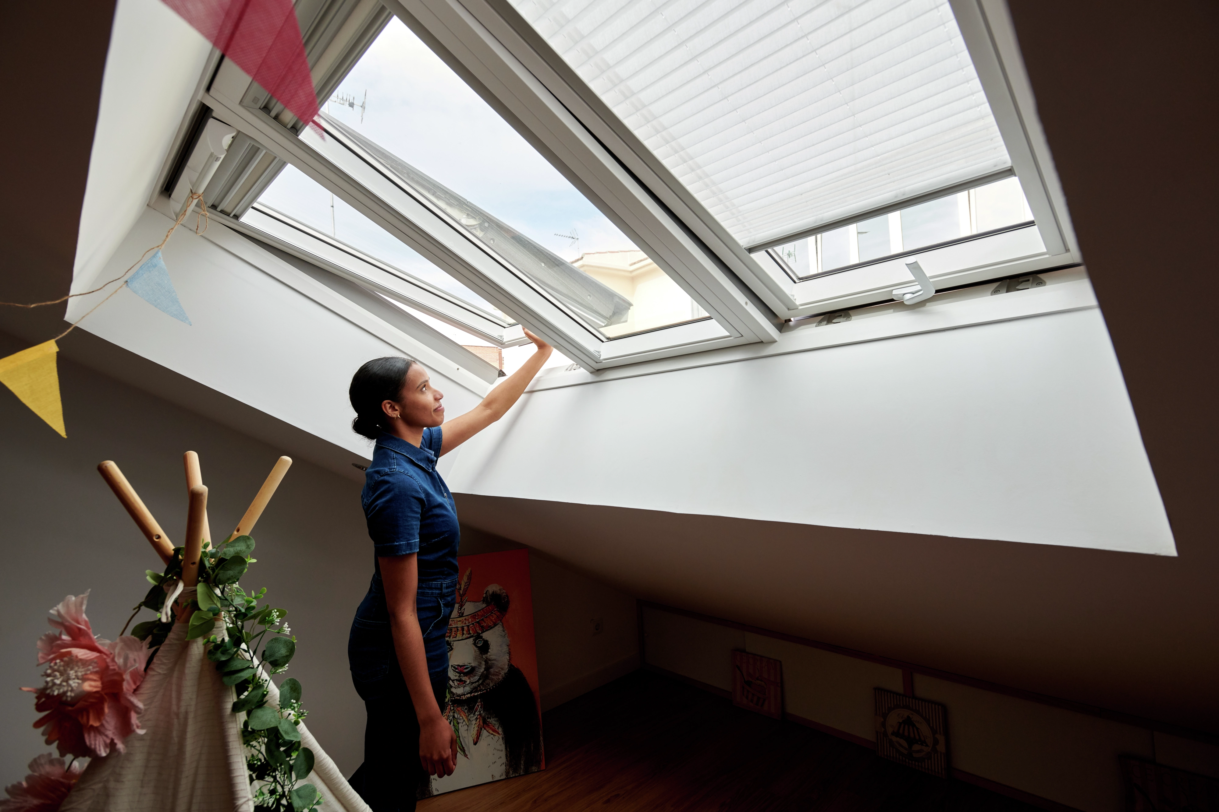 Moteris atidaro VELUX 3 viename stogo langą.