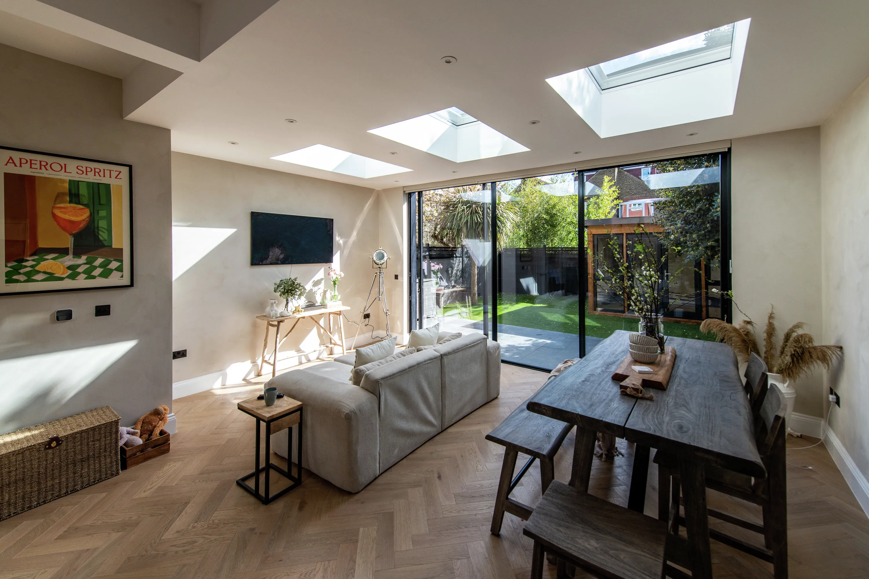 Living room with flat ceiling, VELUX roof windows, and garden view.