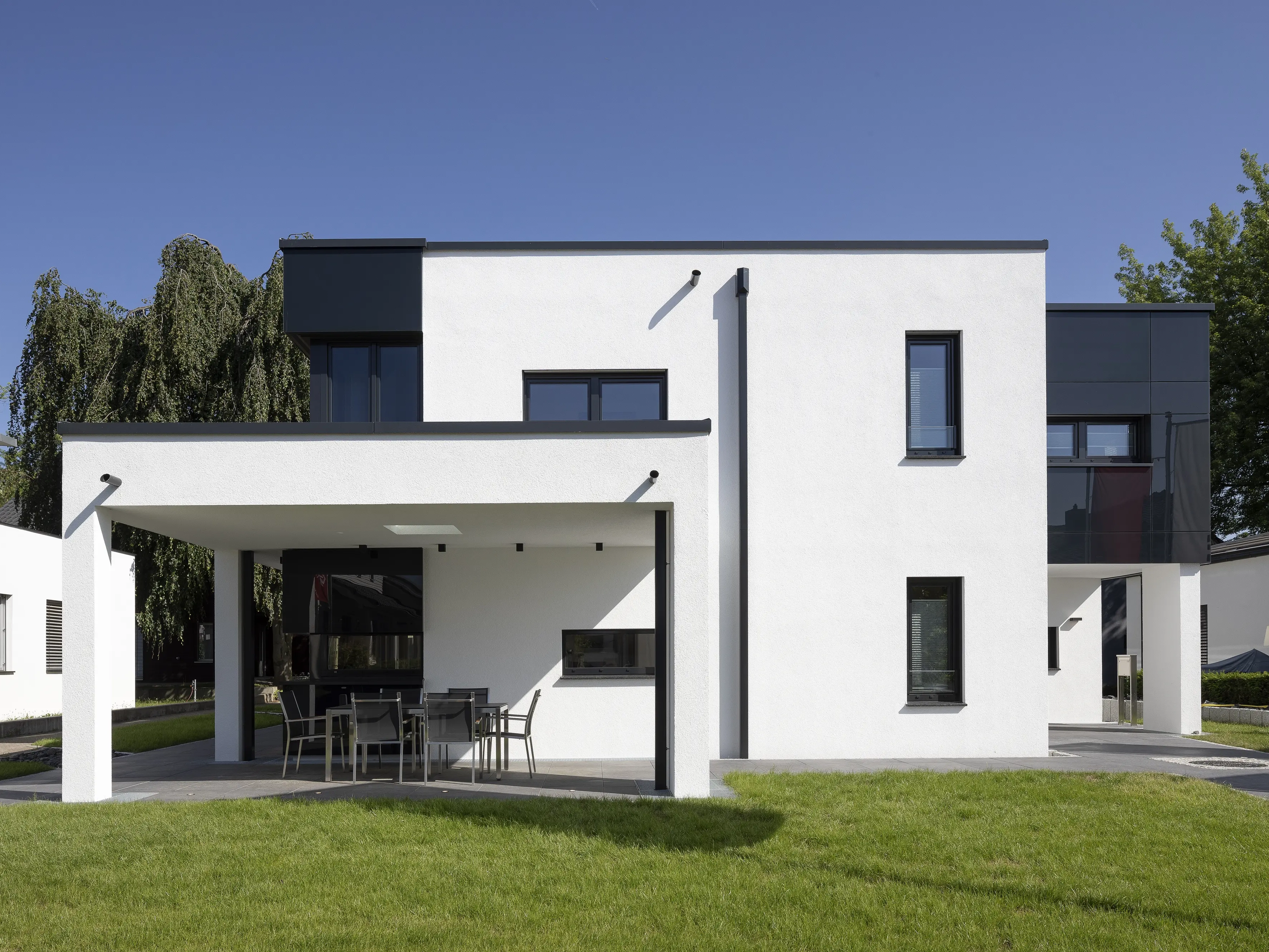 Casa moderna con ampie finestre e tetto piano, con portico esterno.
