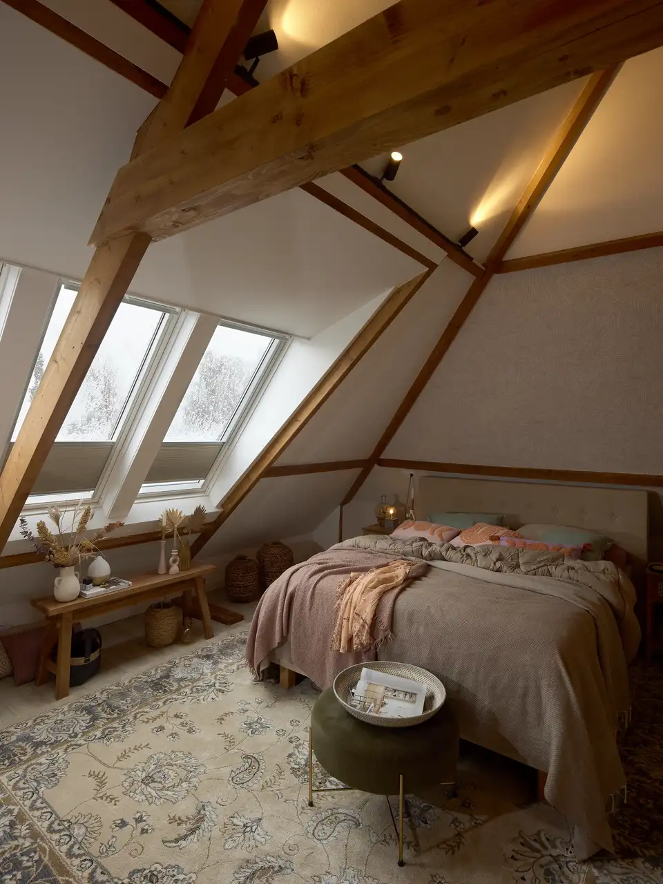 Attic bedroom with sloped ceiling, VELUX windows, and cozy decor.    