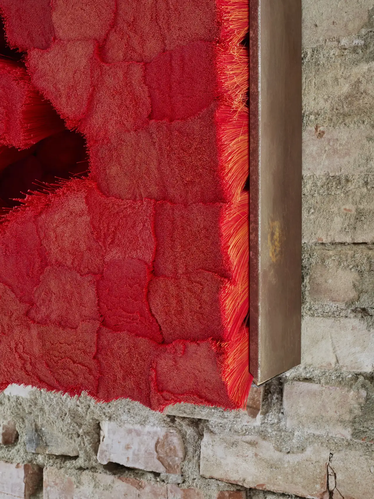 Dettaglio di Setole,  un’opera allestita su un muro di mattoni dello studio.
