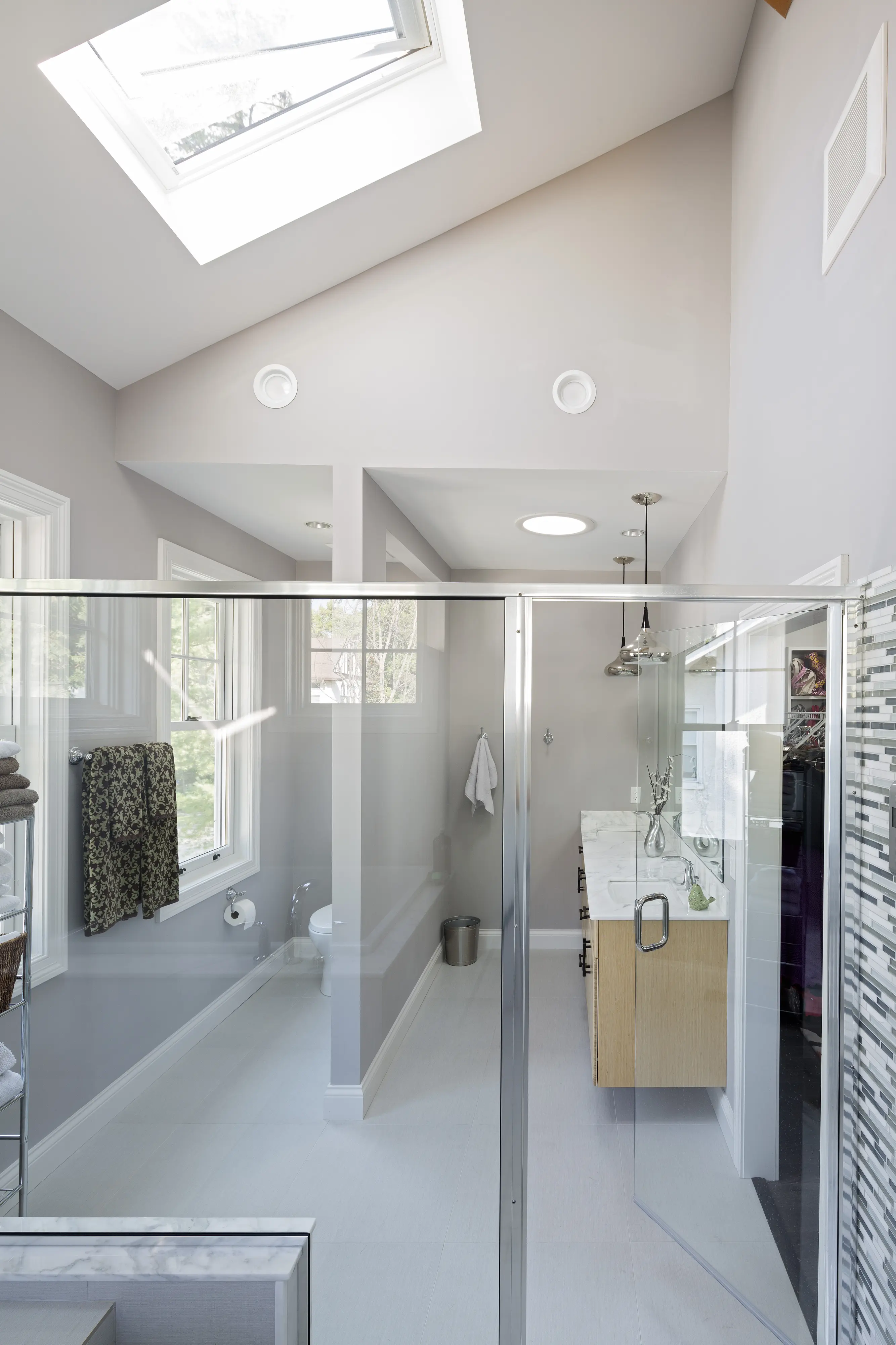Baie cu tavan înclinat și fereastră de mansardă VELUX, cu corpuri de iluminat moderne.
