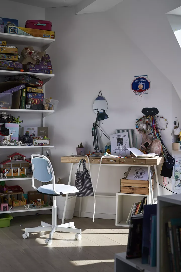 Kinderstudienbereich auf dem Dachboden mit Schreibtisch, Spielzeug und VELUX Dachflächenfenster.