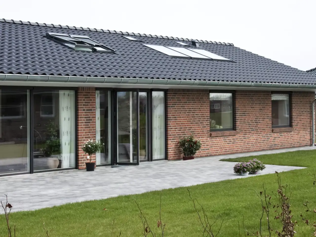 Modern brick house with VELUX roof windows and tiled roof.