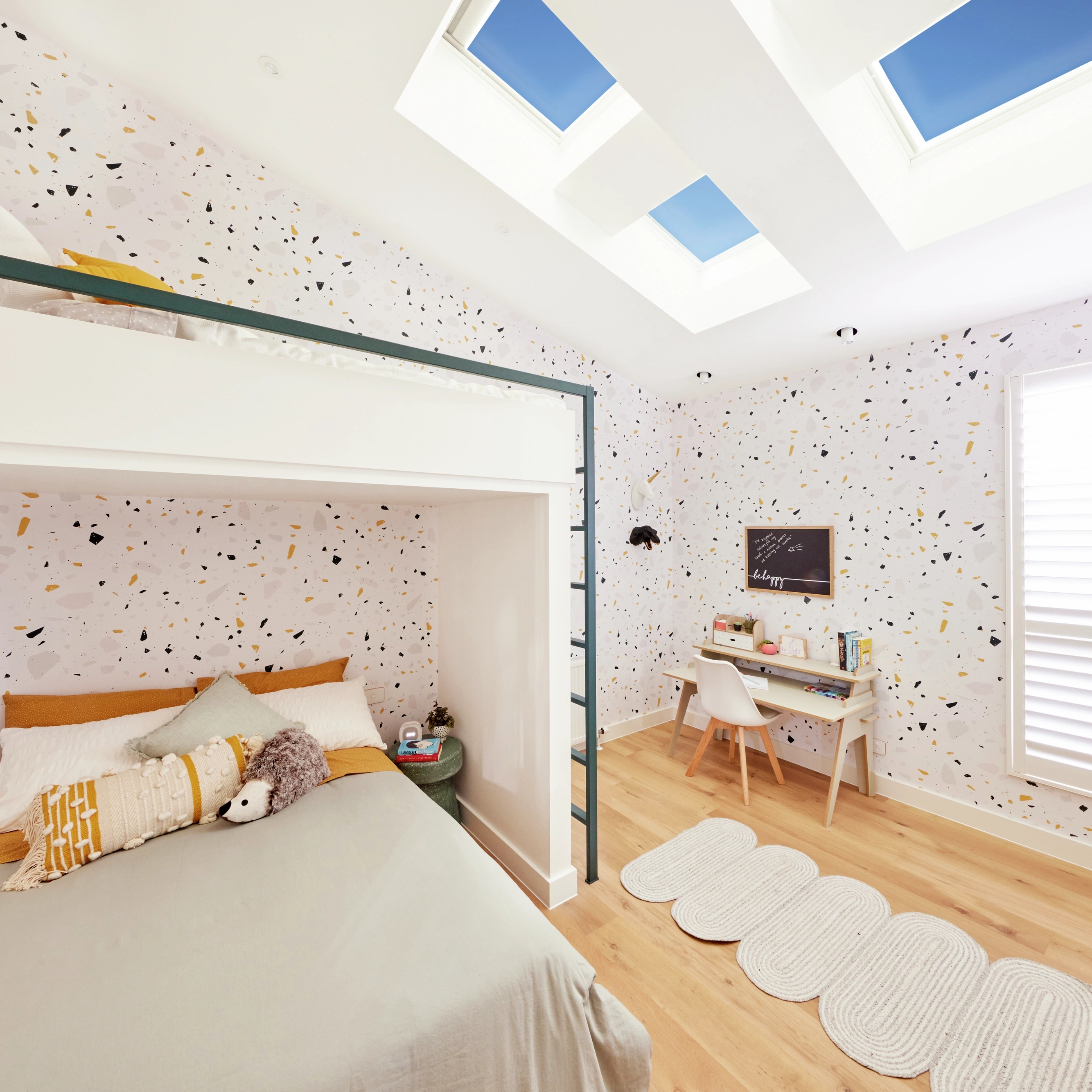 Kids room with loft bed, study area, and skylights.