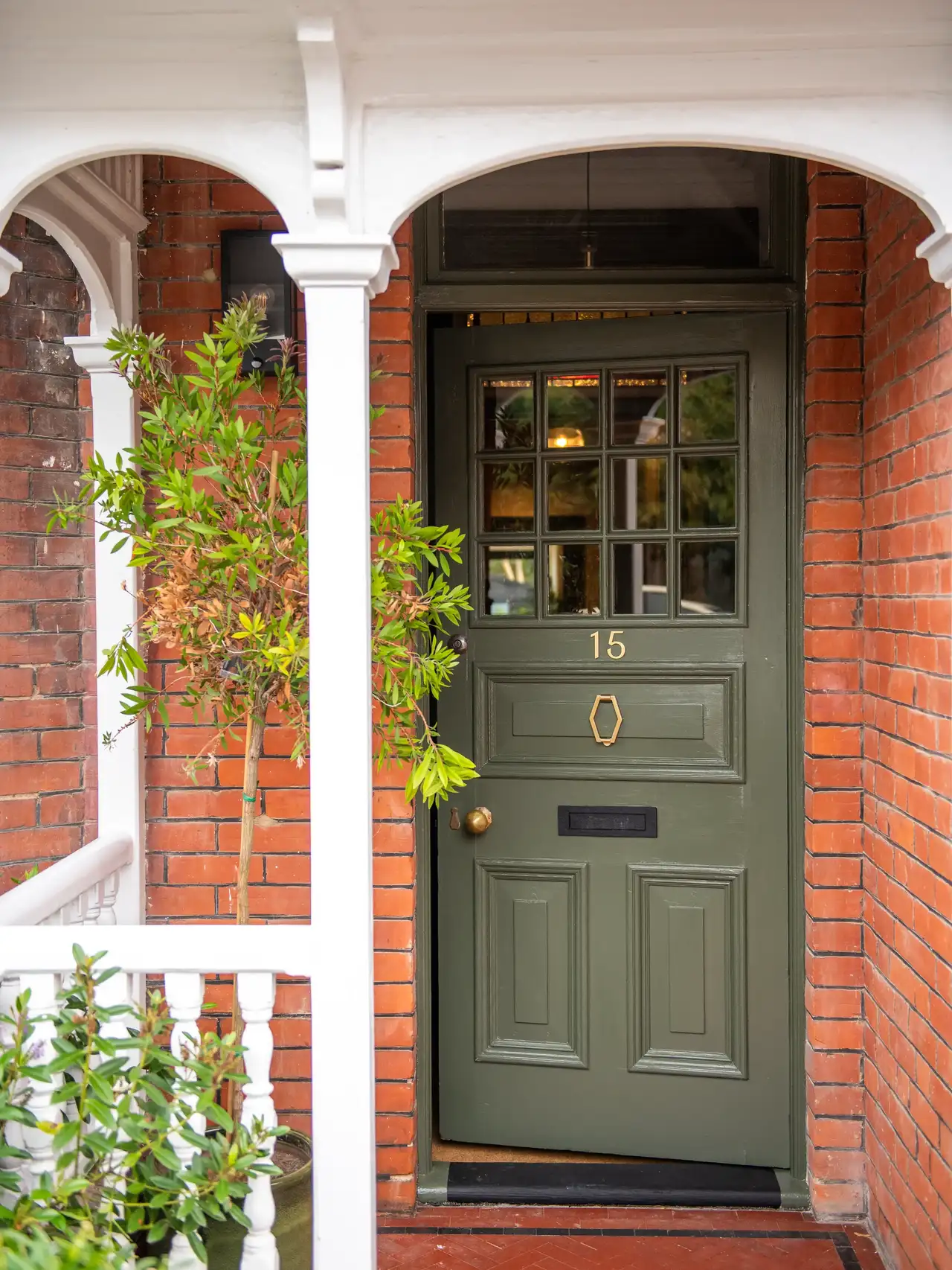 Traditional-style house with red brick and green front door.  
