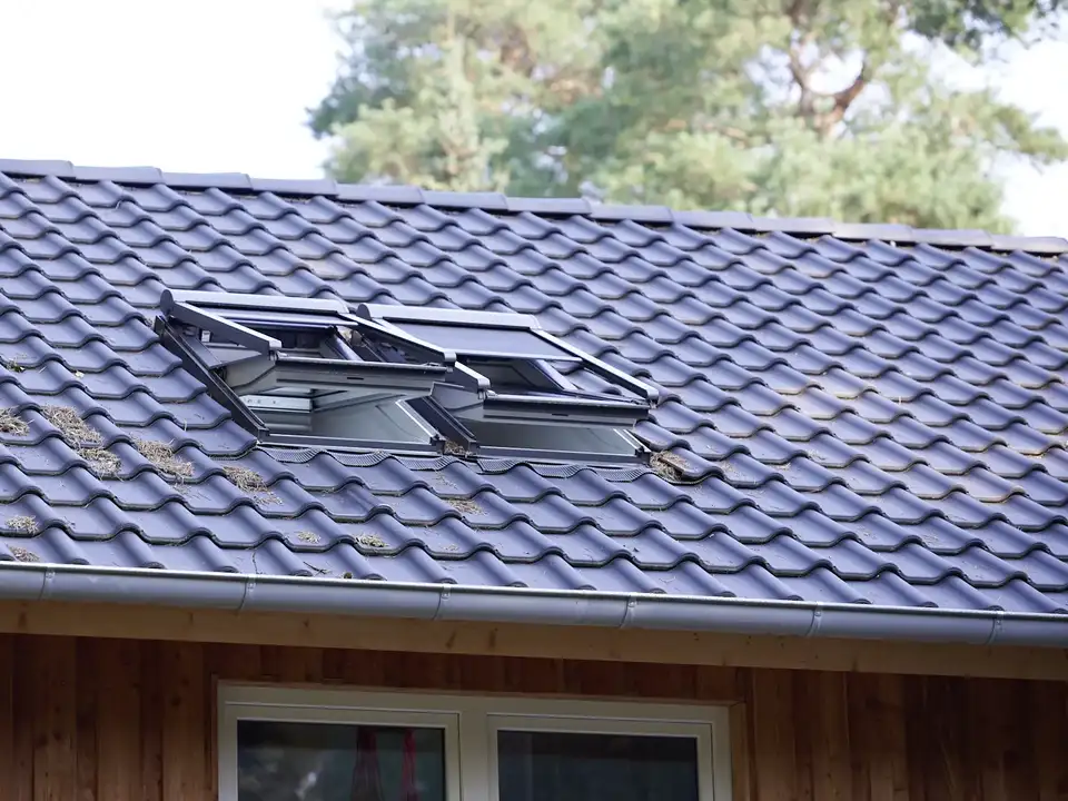 Interiér so strešným oknom vybaveným markízou VELUX, ktorá filtruje slnečné svetlo bez toho, aby bránila výhľadu von.