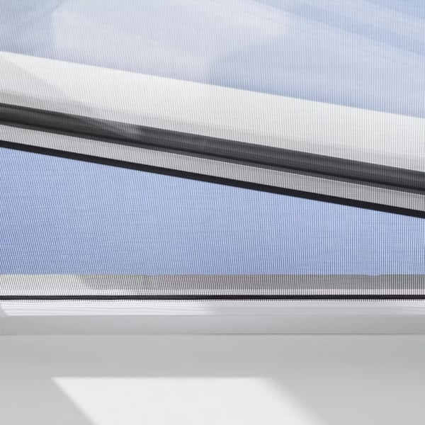 Open VELUX roof window with clear blue sky visible.