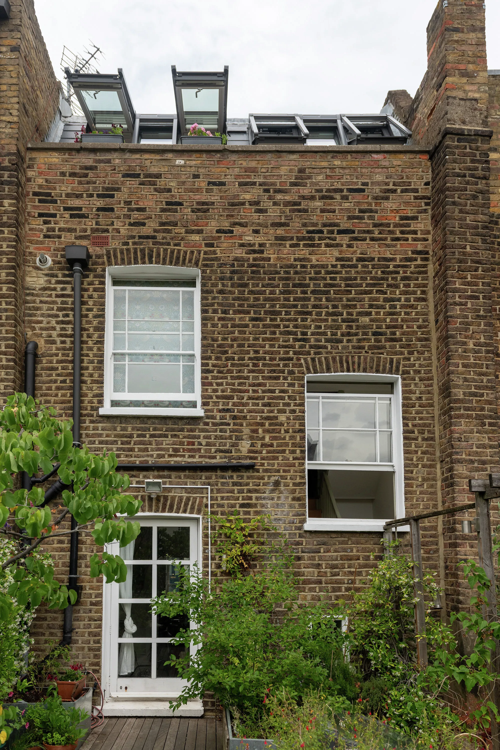 Terraced house with brick facade and VELUX roof windows.
