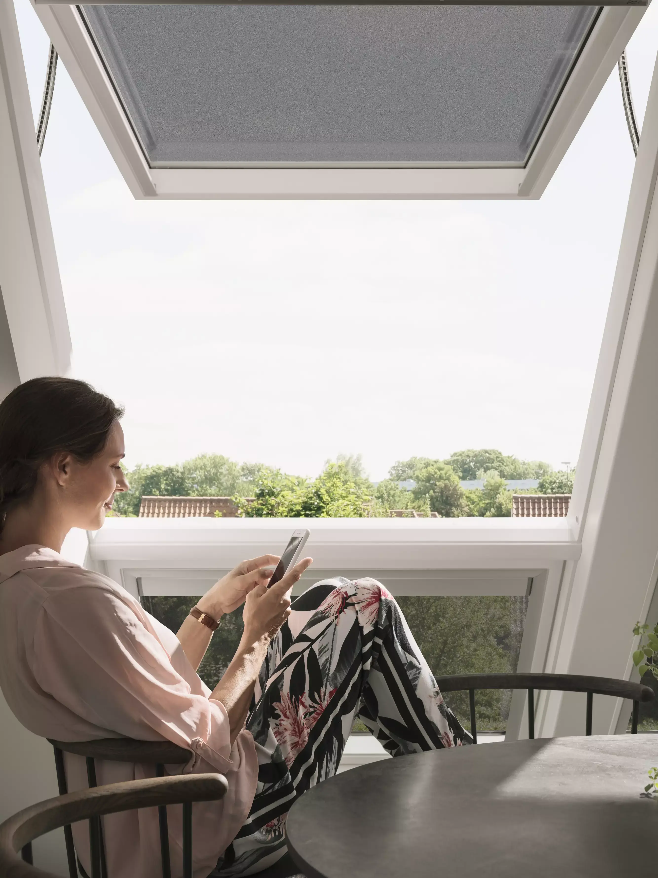 Chambre de comble confortable avec lumière naturelle d'une fenêtre de toit VELUX, meublée pour la détente.