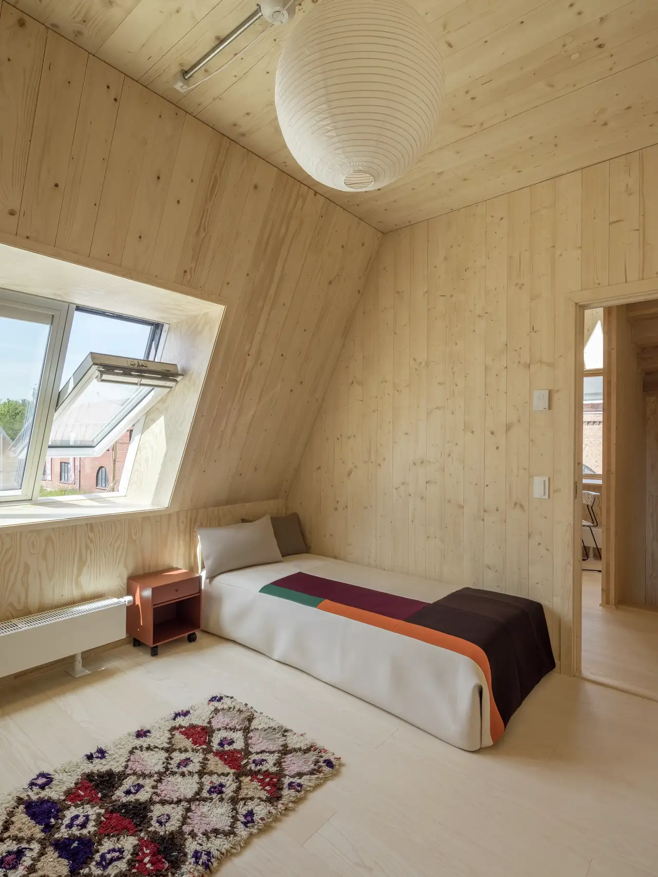 Camera da letto elegante con pannelli in legno e lucernario aperto | Rivista VELUX