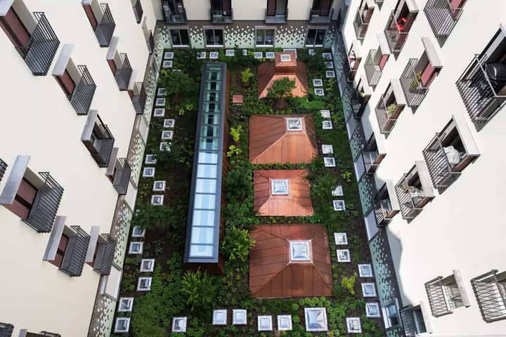 Luftaufnahme eines Apartmentinnenhofs mit Garten, Terrassen und VELUX Dachflächenfenstern.