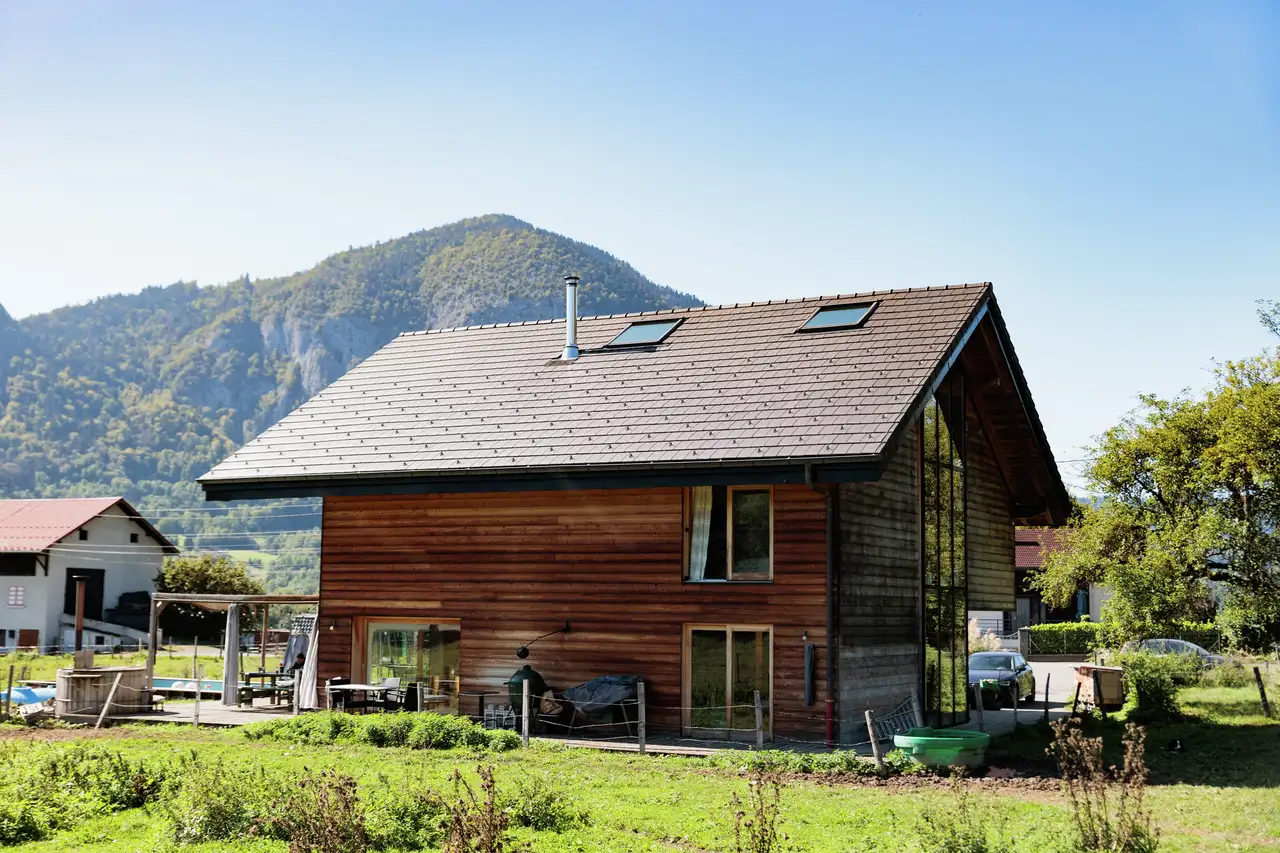 chalet de montagne au toit à forte pente avec fenêtres de toit VELUX, vue sur les montagnes