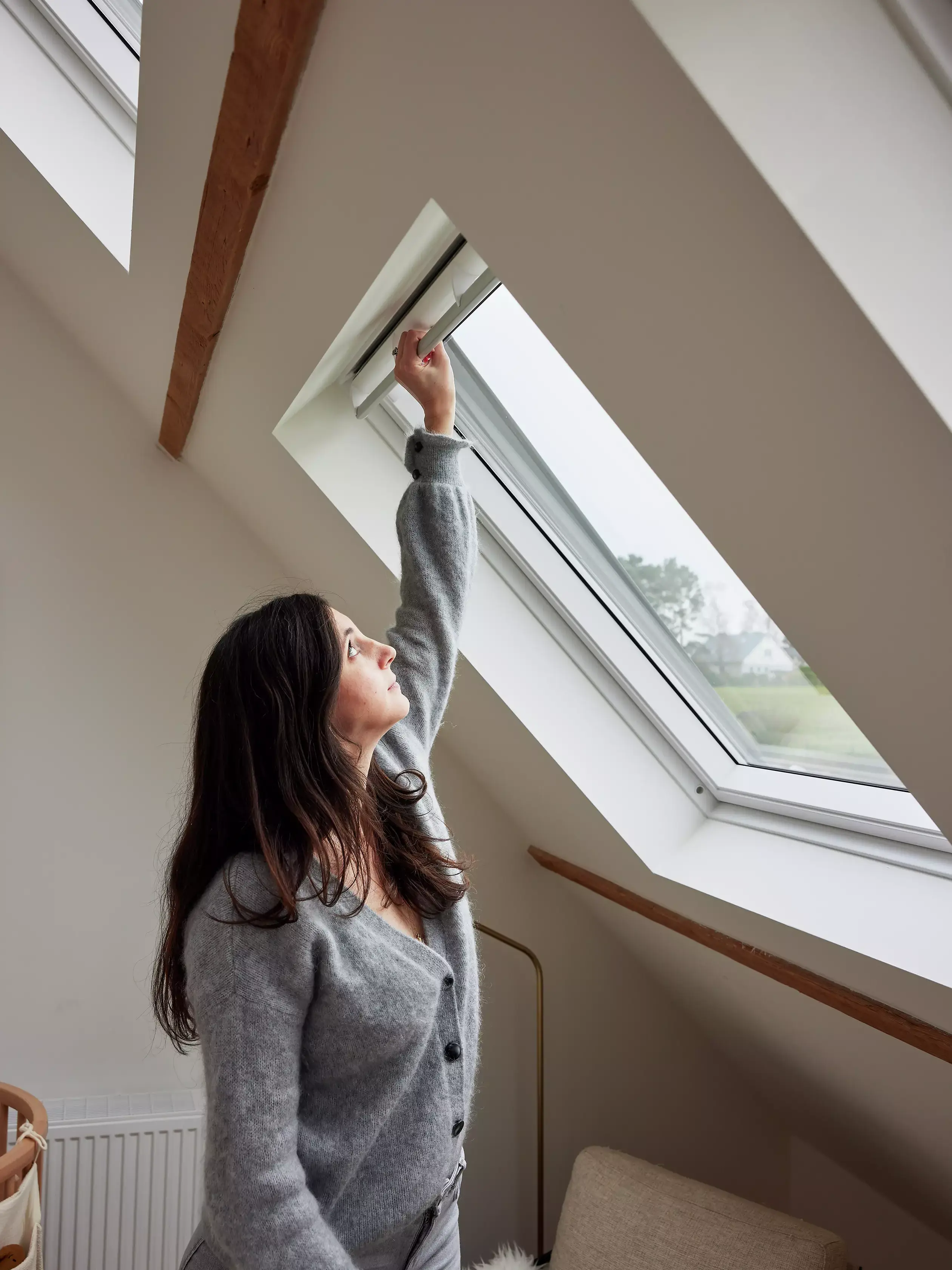 Professionisti VELUX che installano una nuova finestra per tetti in un elegante ufficio domestico.