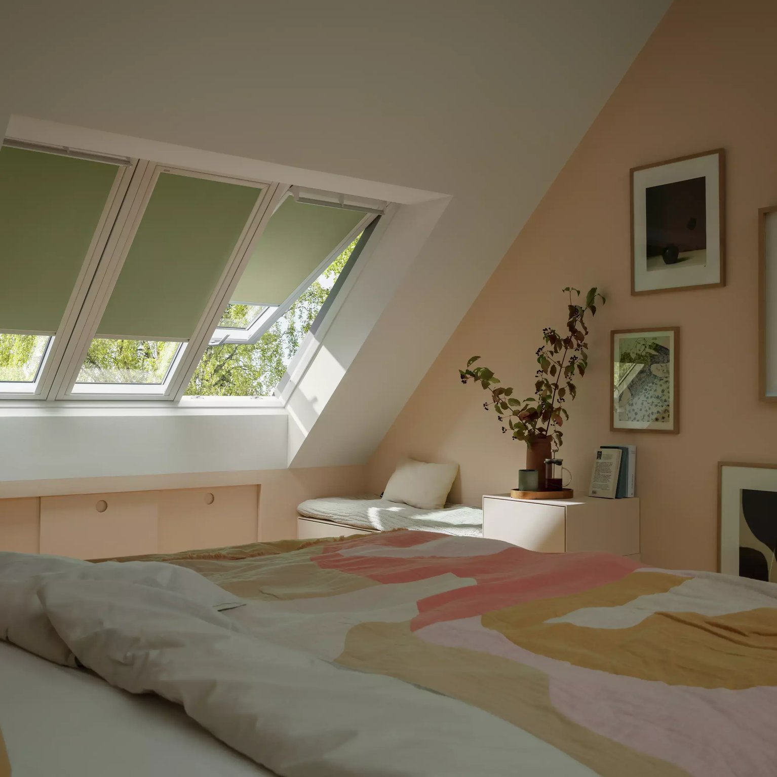 Attic bedroom with sloped ceiling and VELUX roof window, pastel decor.