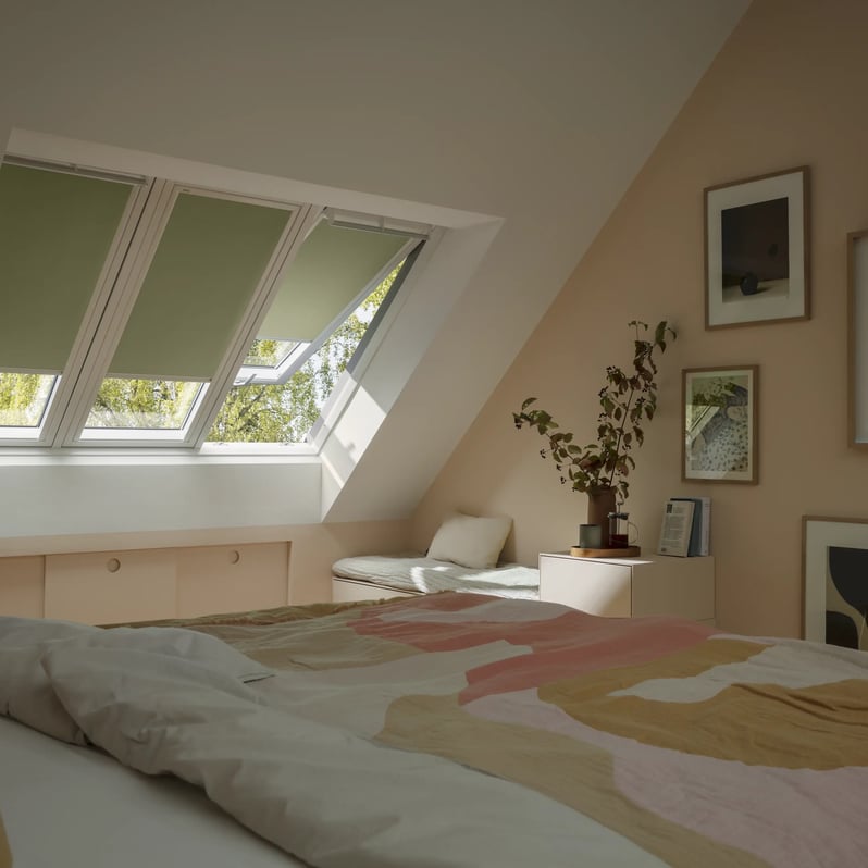 Attic bedroom with sloped ceiling and VELUX roof window, pastel decor.