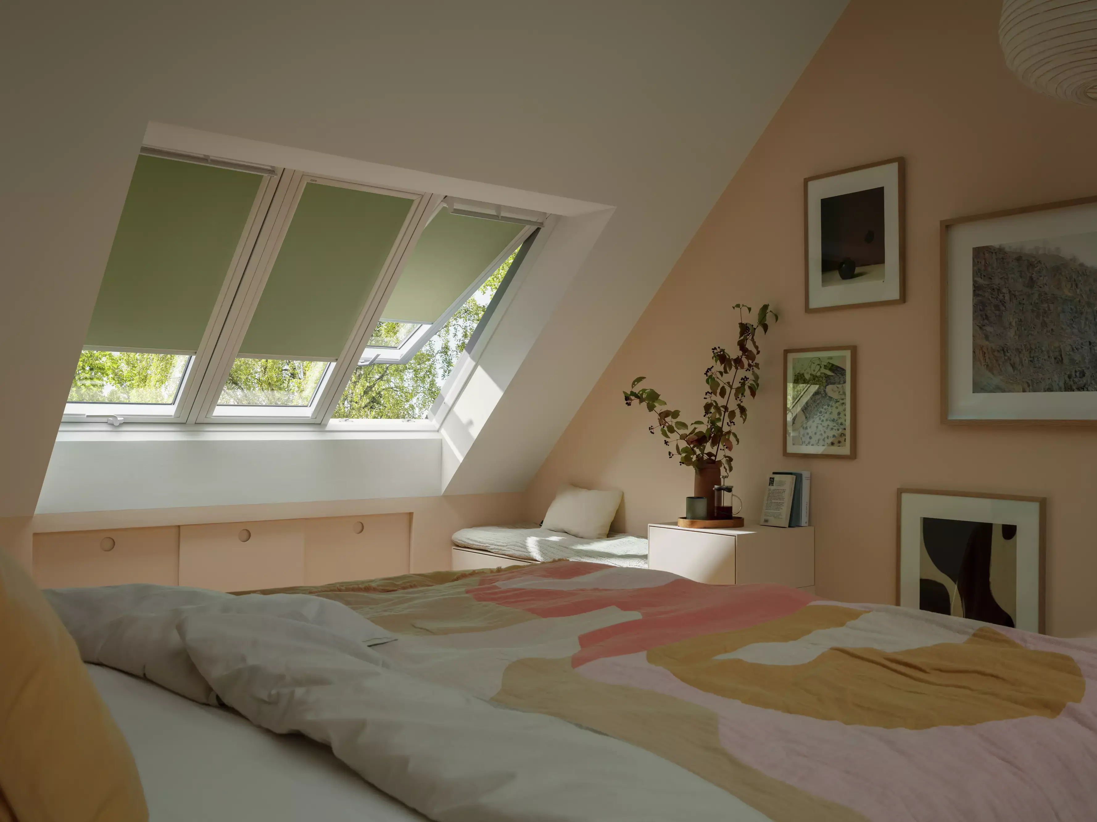 Chambre mansardée confortable avec des fenêtres de toit VELUX et une décoration de bon goût.