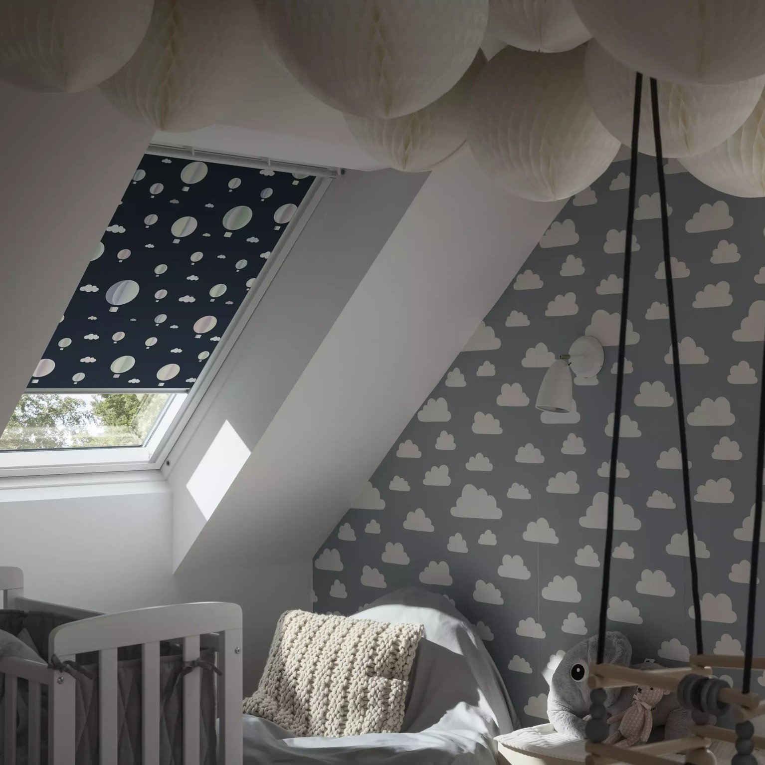 Attic kids room with sloped ceiling, VELUX roof window, cloud wallpaper.