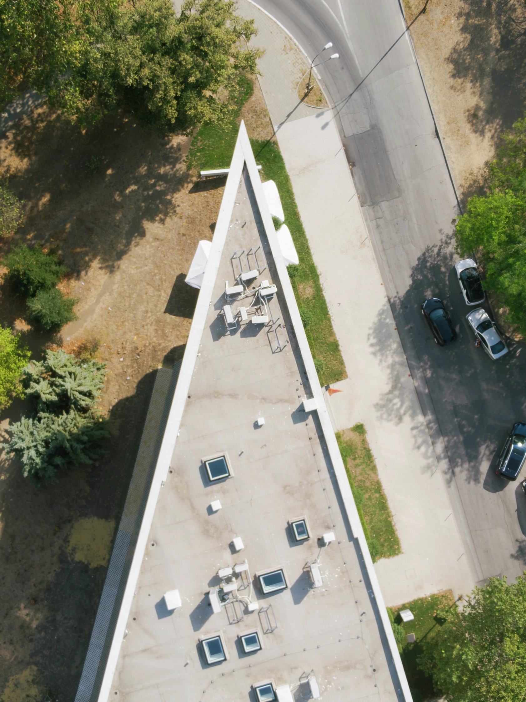 Aerial view of triangular flat roof building with VELUX flat roof windows and surrounding streets.