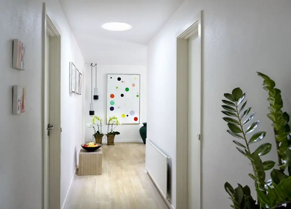 Gang verlicht door een lichttunnel in het plafond