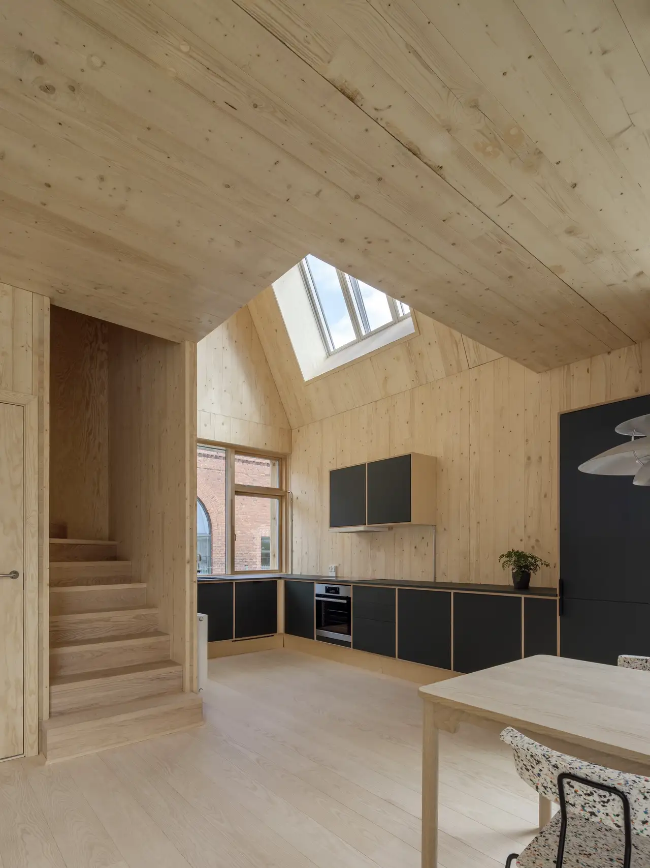Cucina abitabile moderna con frontali neri in una casa in legno | Rivista VELUX