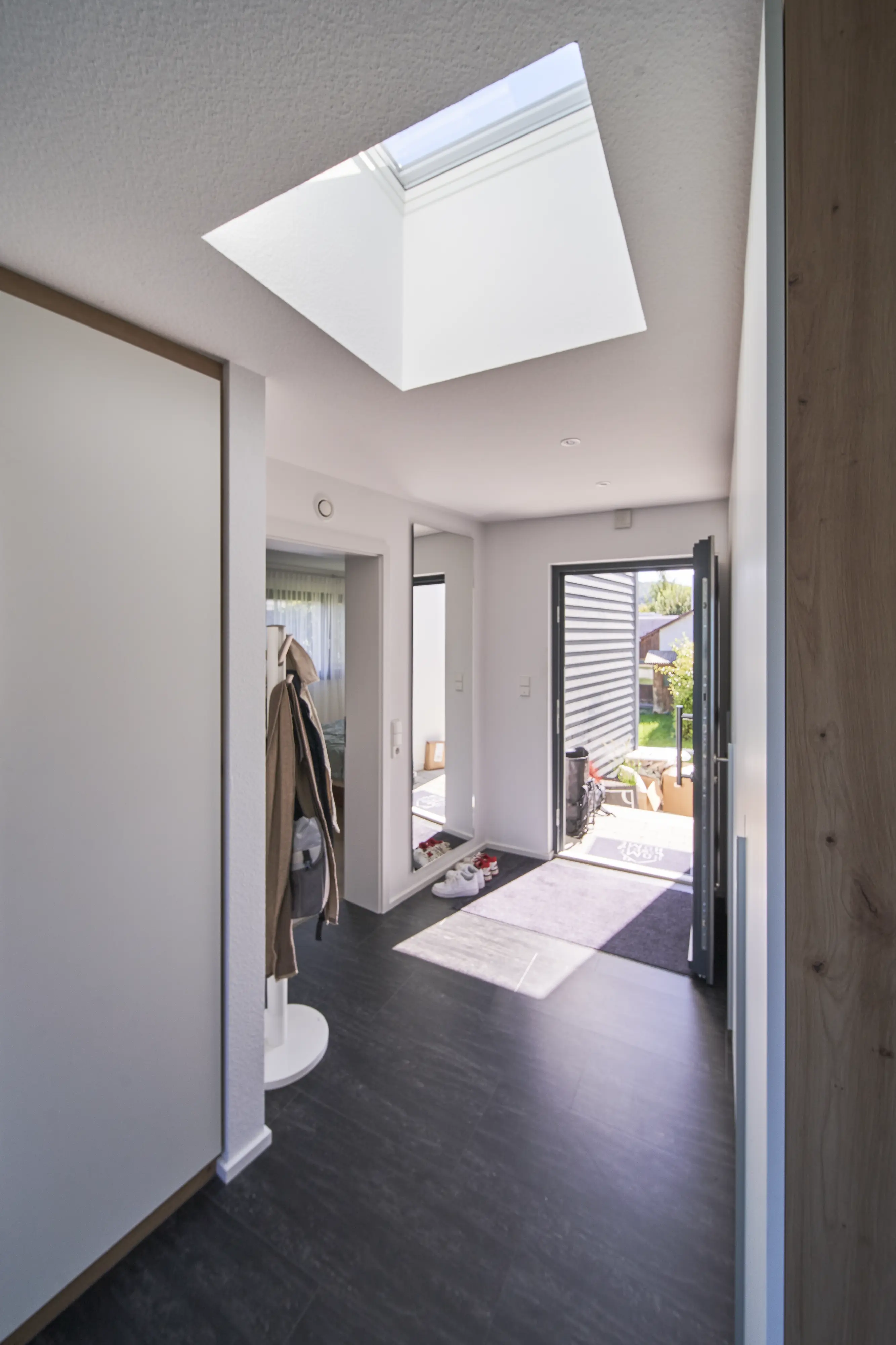 Moderns priekšnams ar VELUX jumta logu, dabisko apgaismojumu un skatu uz dārzu.