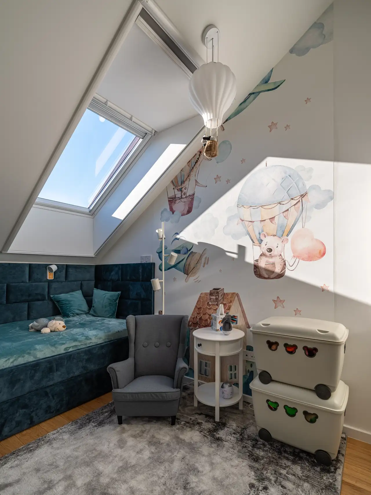 Kids attic room with sloped ceiling and VELUX roof window, playful wall decals. 