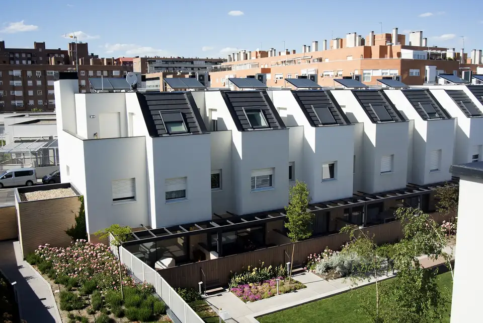 Villette a schiera moderne con finestre per tetti VELUX e piccoli giardini.