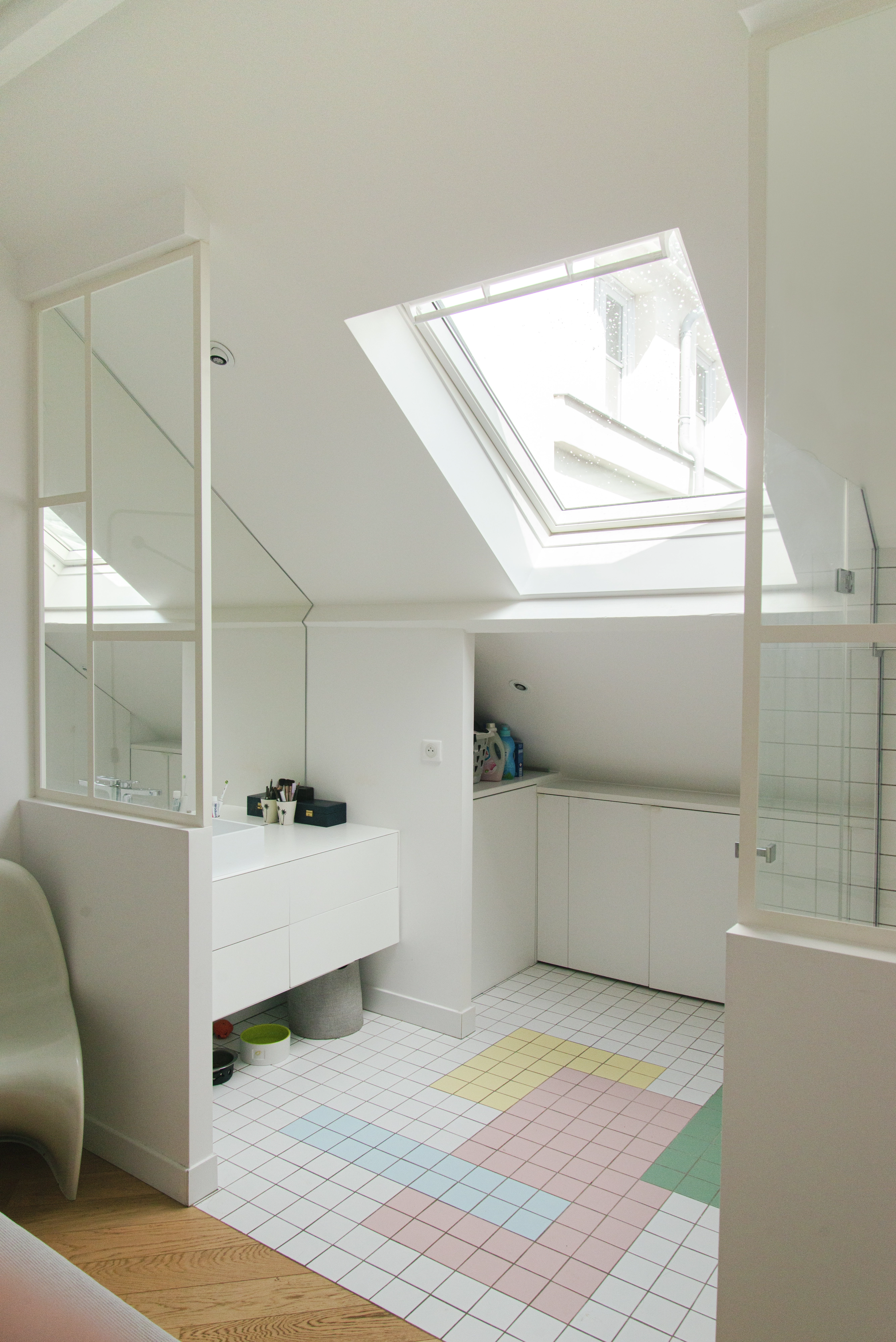 Bēniņu vannas istaba ar slīpiem griestiem un VELUX jumta logu, gaišs un moderns dizains.