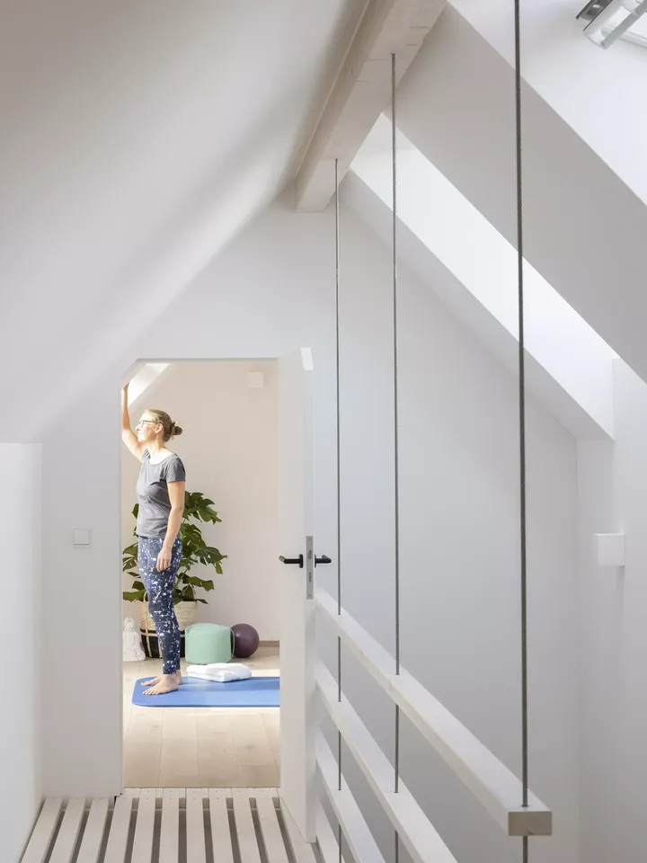 Heller Dachboden-Yogaraum mit VELUX Dachflächenfenster und hölzernem Boden.
