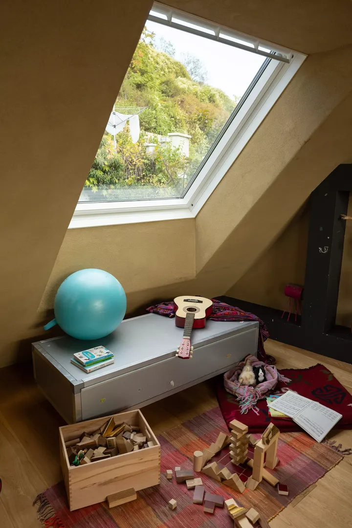 Spielzimmer im Dachboden mit VELUX-Fenster, Spielzeug am Boden und natürlichem Licht.