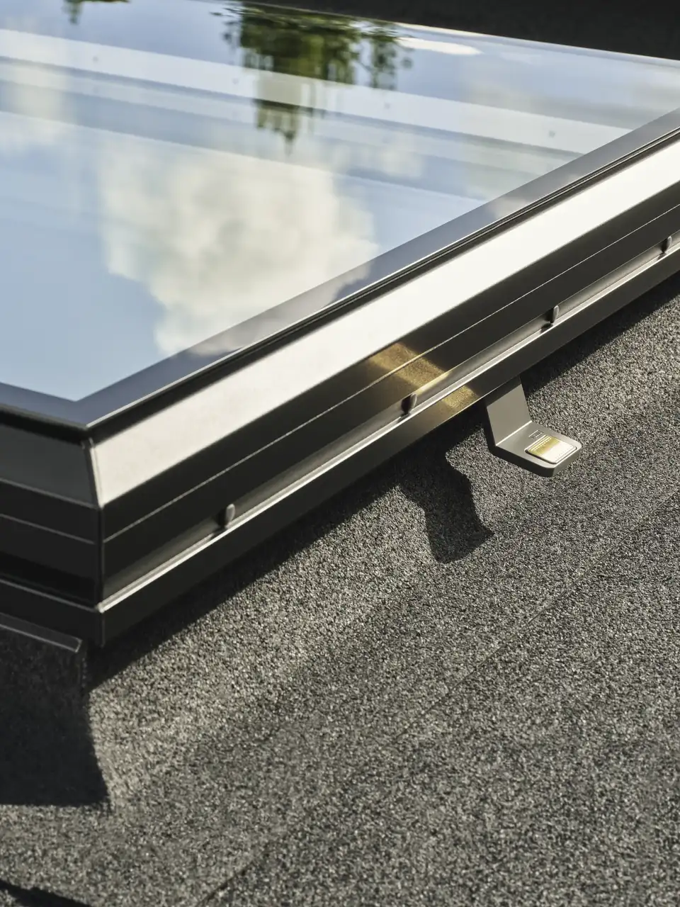 Close-up detail of VELUX Standard glass rooflight installed on a felt flat roof - modern low profile rooflight.