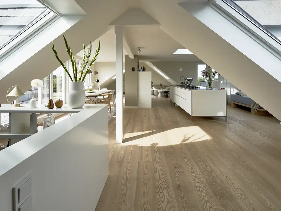 Open space in mansarda con finestre per tetti VELUX sulle falde opposte del tetto 