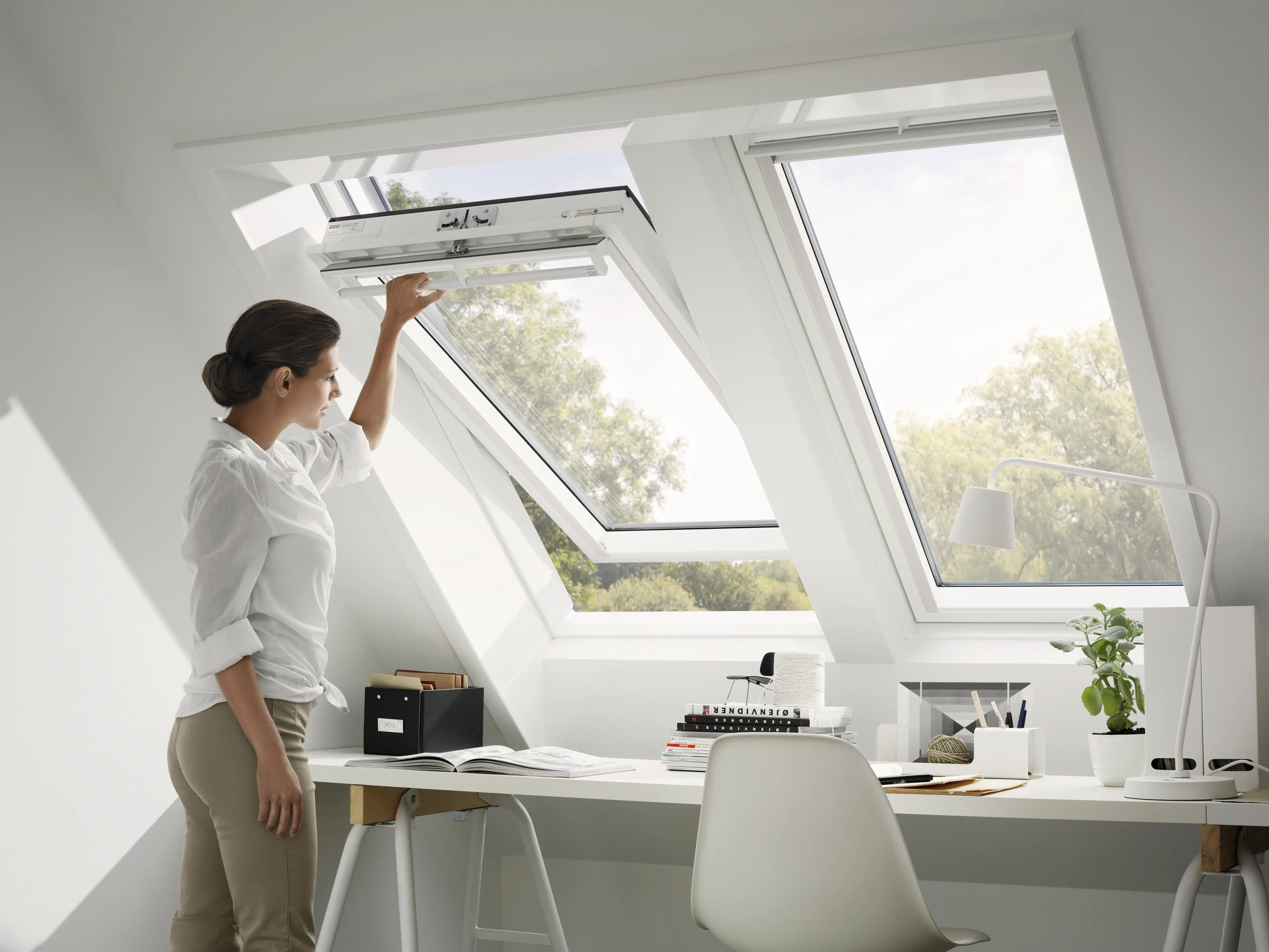 Frau öffnet Fenster unter Dachschräge mit Tageslichteinfall | VELUX Magazin