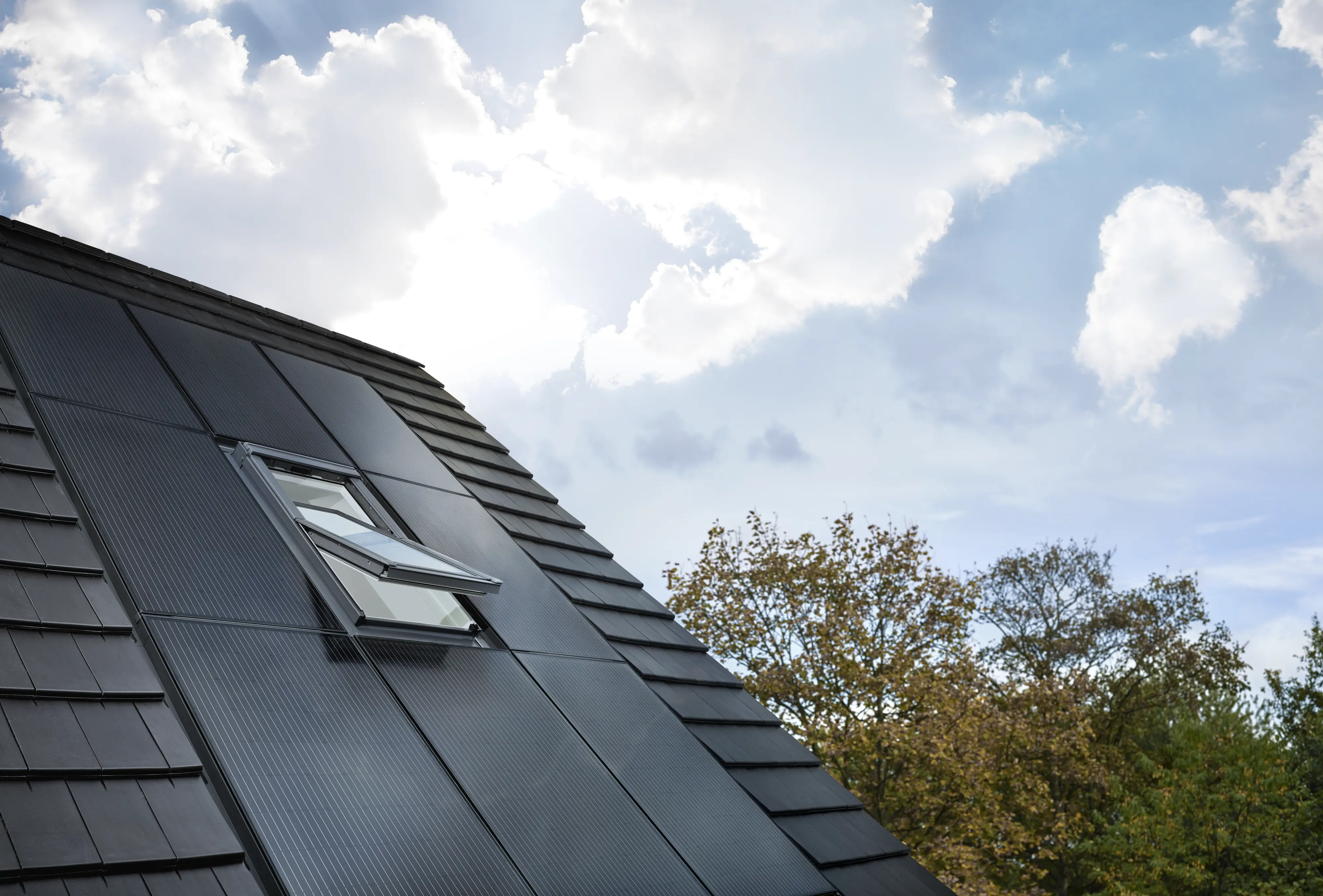 Modern tető fotovoltaikus panelekkel és nyitott VELUX tetőablakkal.