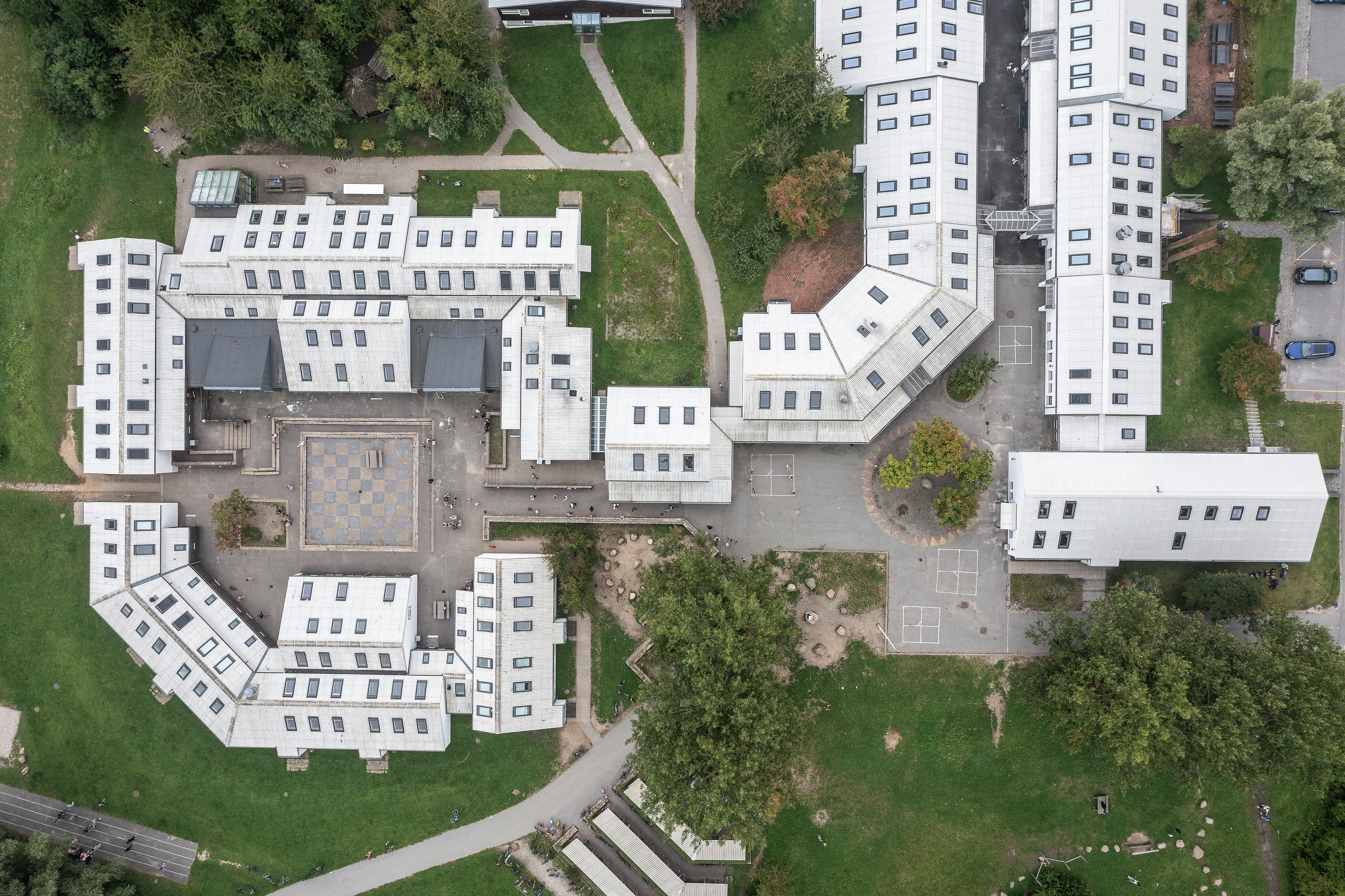 Vedere aeriană a unui campus educațional cu acoperișuri plate și ferestre de mansardă VELUX.