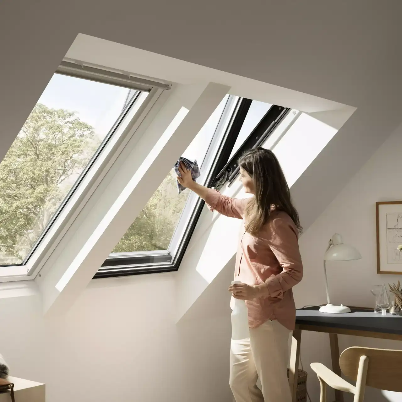 Helles Dachboden-Homeoffice mit offenem VELUX Dachflächenfenster und natürlichem Licht.