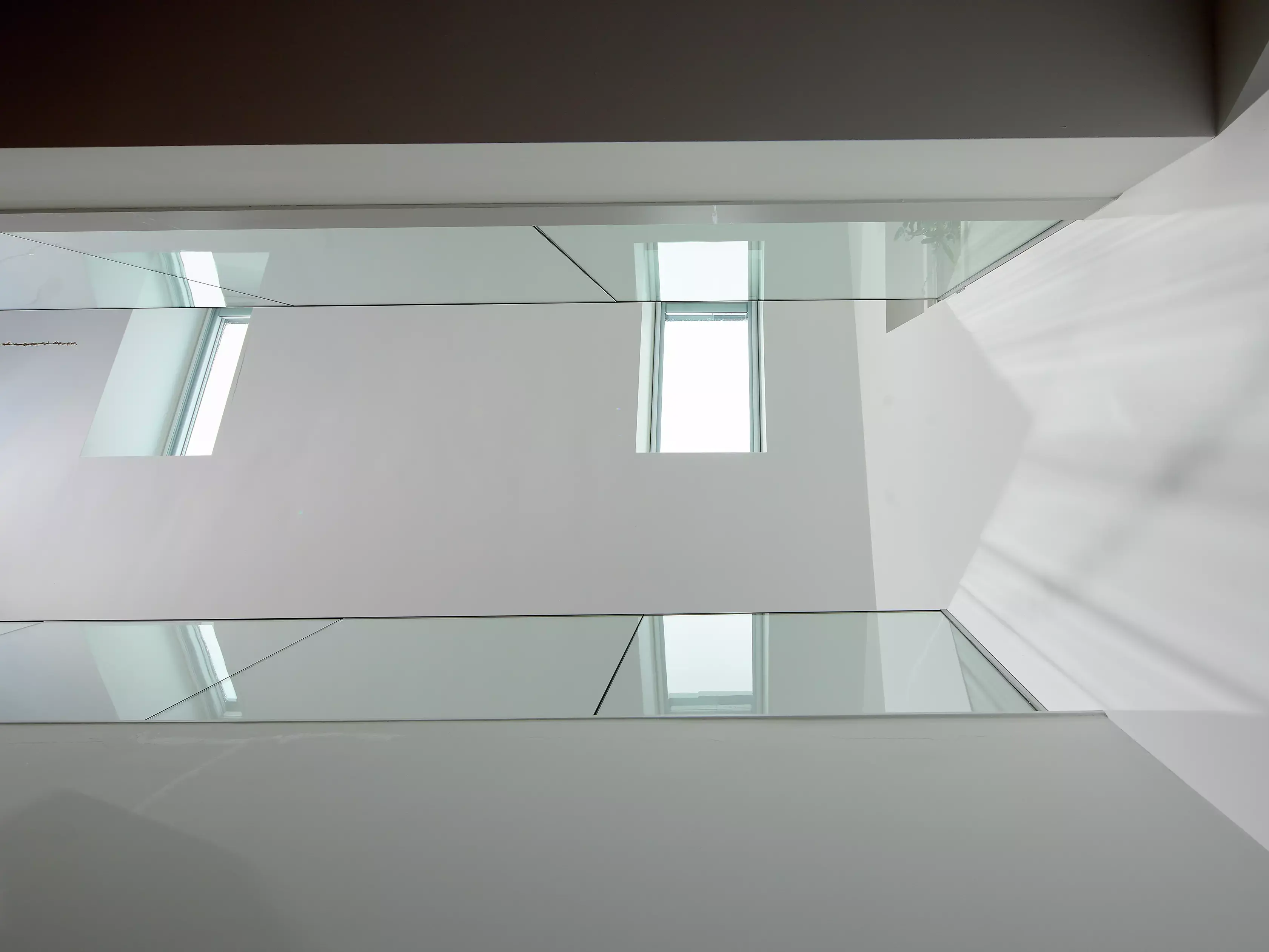Couloir avec parapet en verre vu d'en bas.