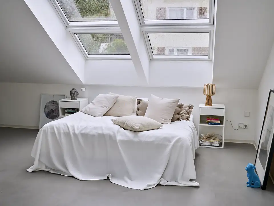  lit double avec drap blanc léger sous deux verrières planes VELUX côte à côte 