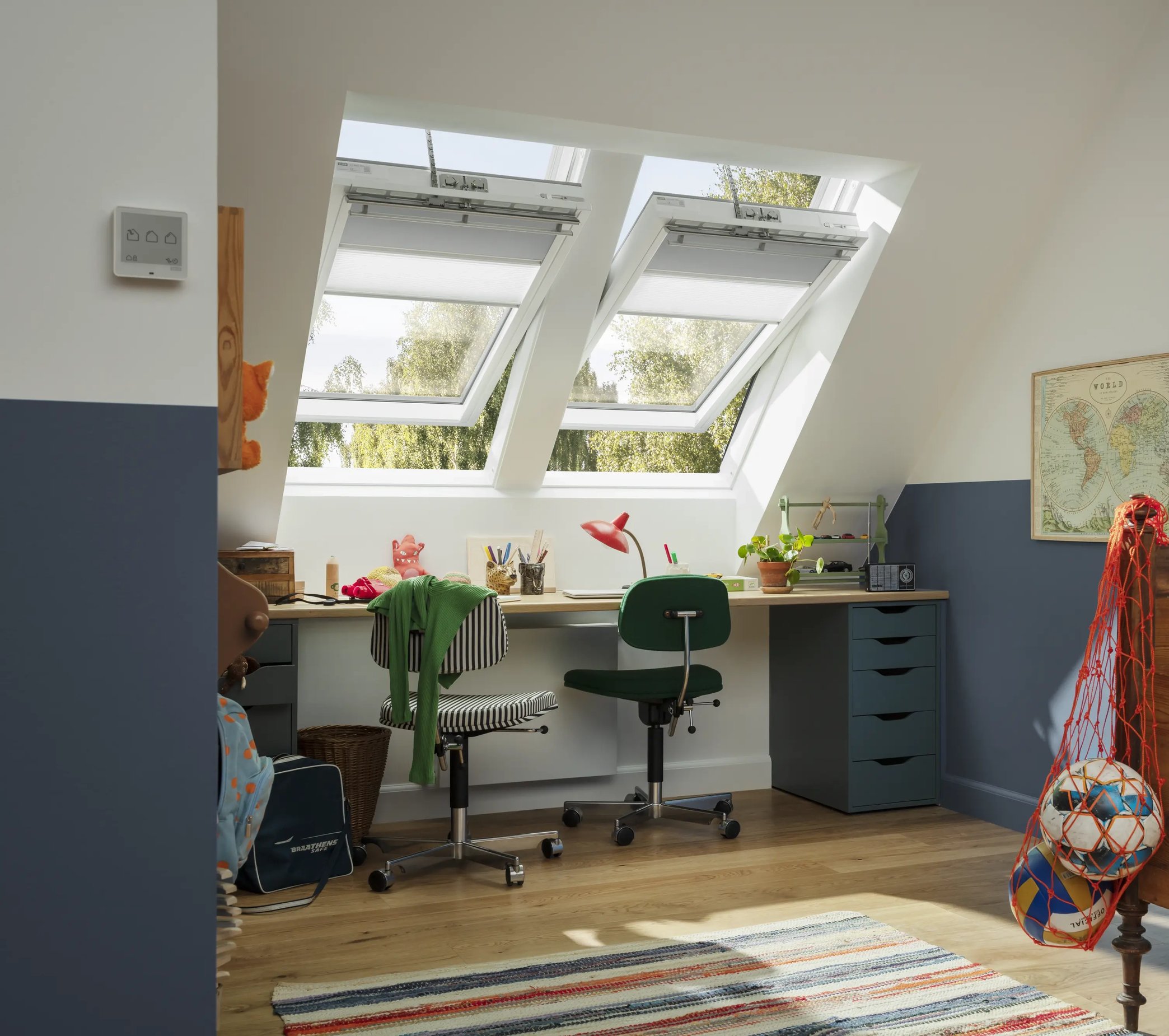 Attic teenage room with sloped ceiling and open VELUX roof windows.