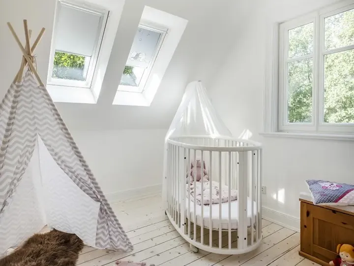 Weißes Babybett mit Kuschelhase unter der Dachschräge | VELUX Magazin