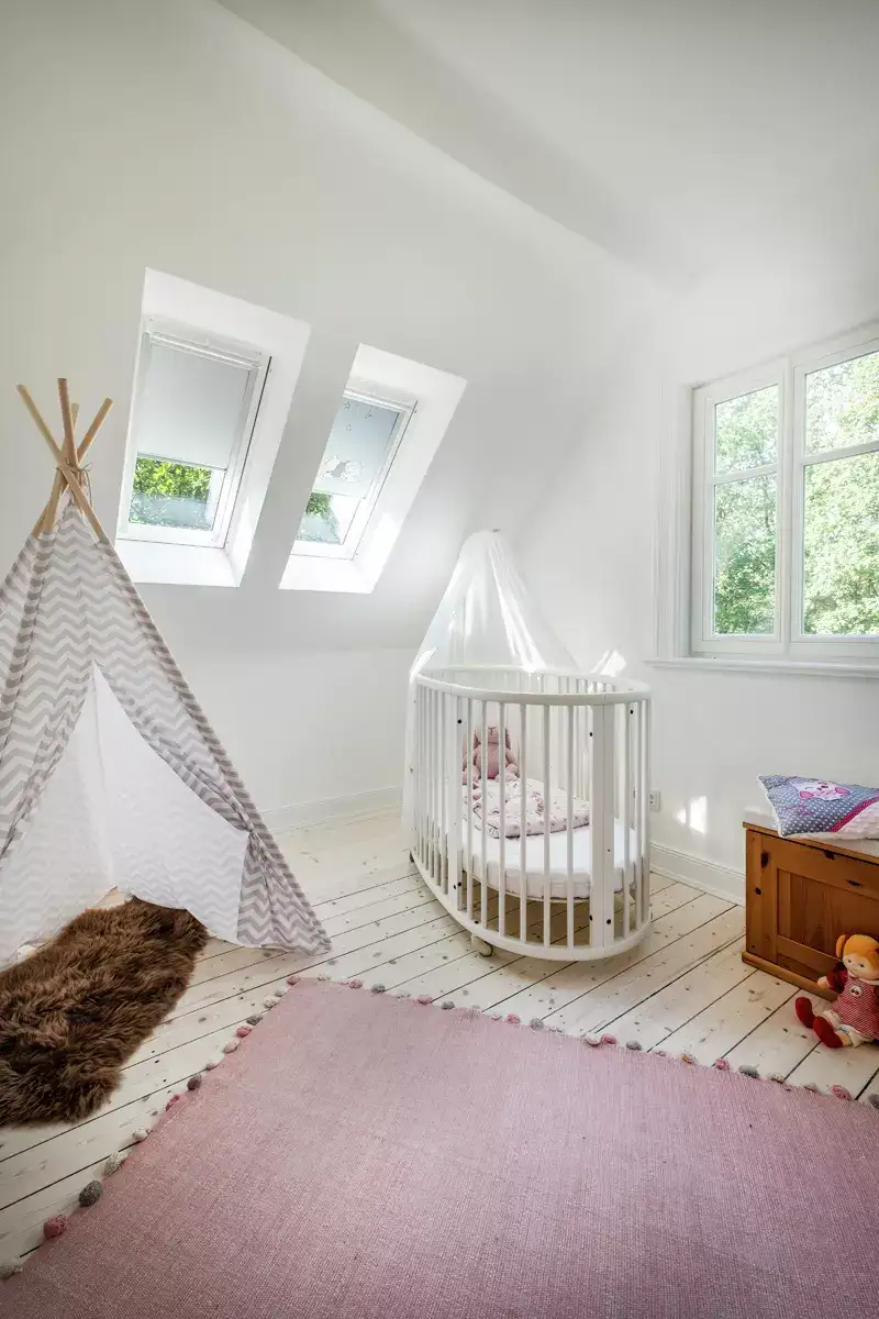 Weißes Babybett mit Kuschelhase unter der Dachschräge | VELUX Magazin