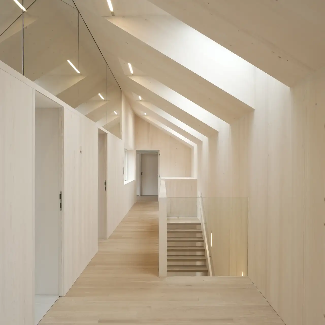 Interiér chodby se střešními okny VELUX poskytujícími světlo.