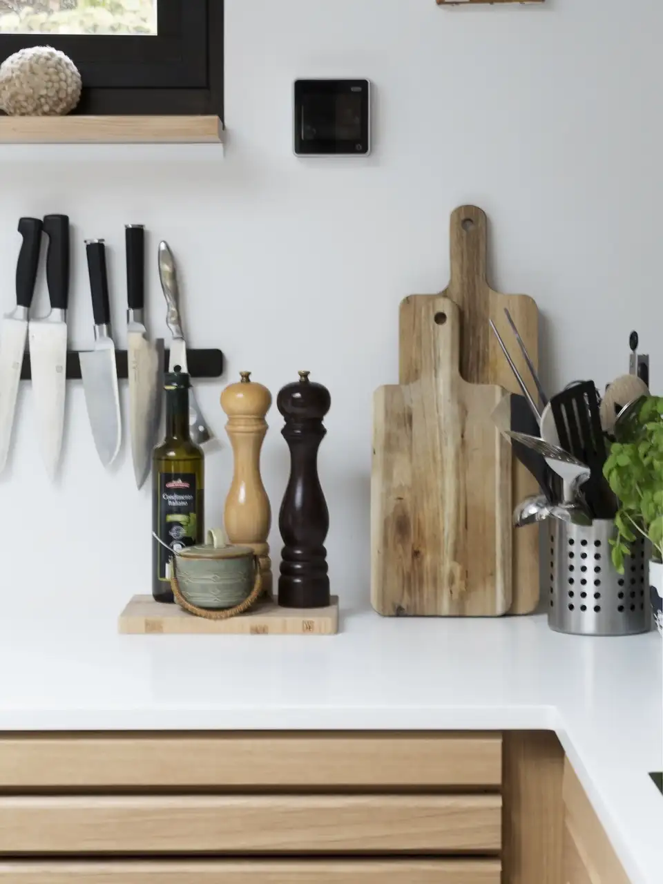 Modern kitchen countertop with knives, cutting boards, and cooking essentials.