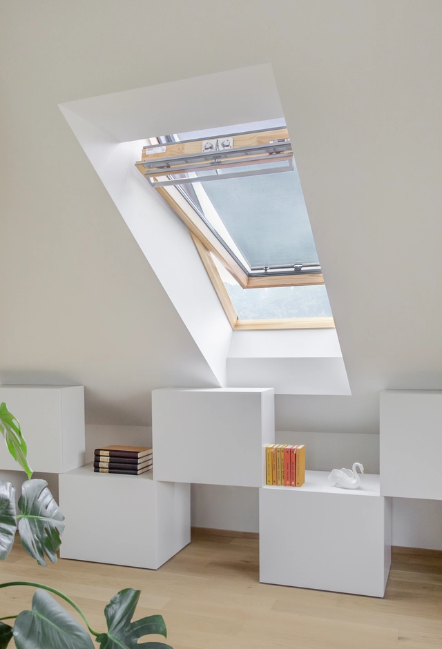 Prostorija sa krovnim prozorom i policom punom knjiga.