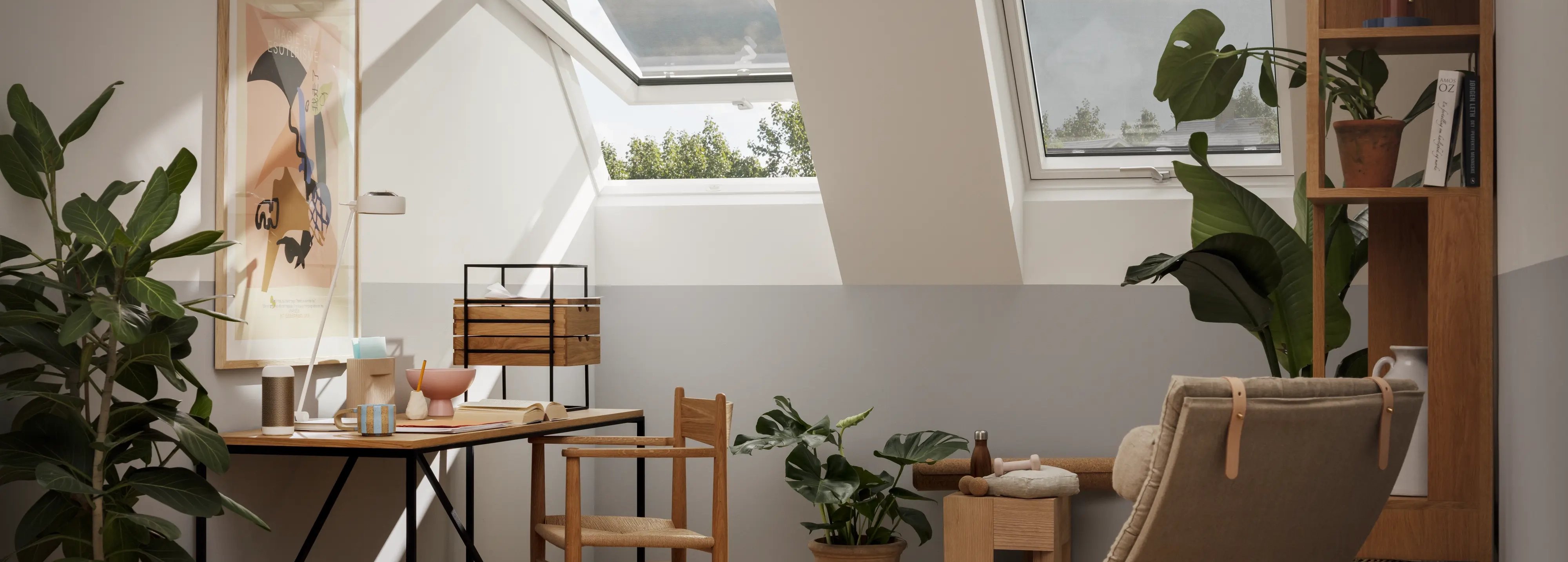 Attic workspace with sloped ceiling and VELUX roof windows, natural light.