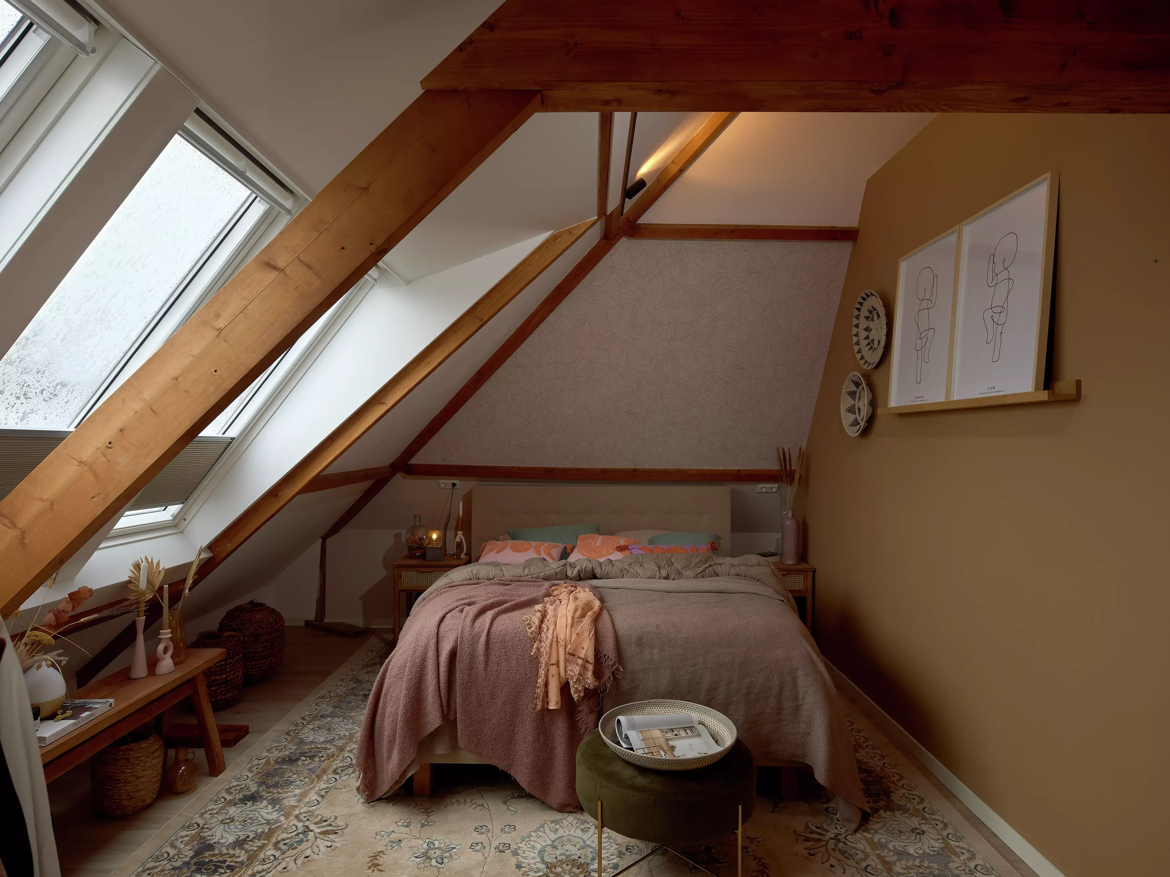 Chambre de comble avec fenêtre de toit VELUX, poutres en bois, et literie rose.