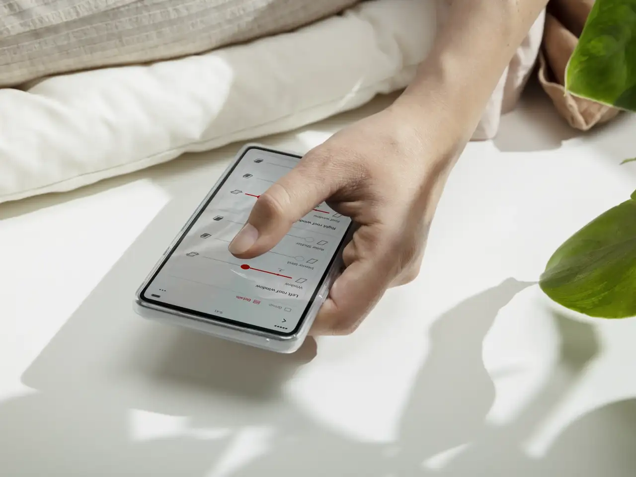 Una mano comanda la Smart Control App di VELUX sullo smartphone | Rivista VELUX