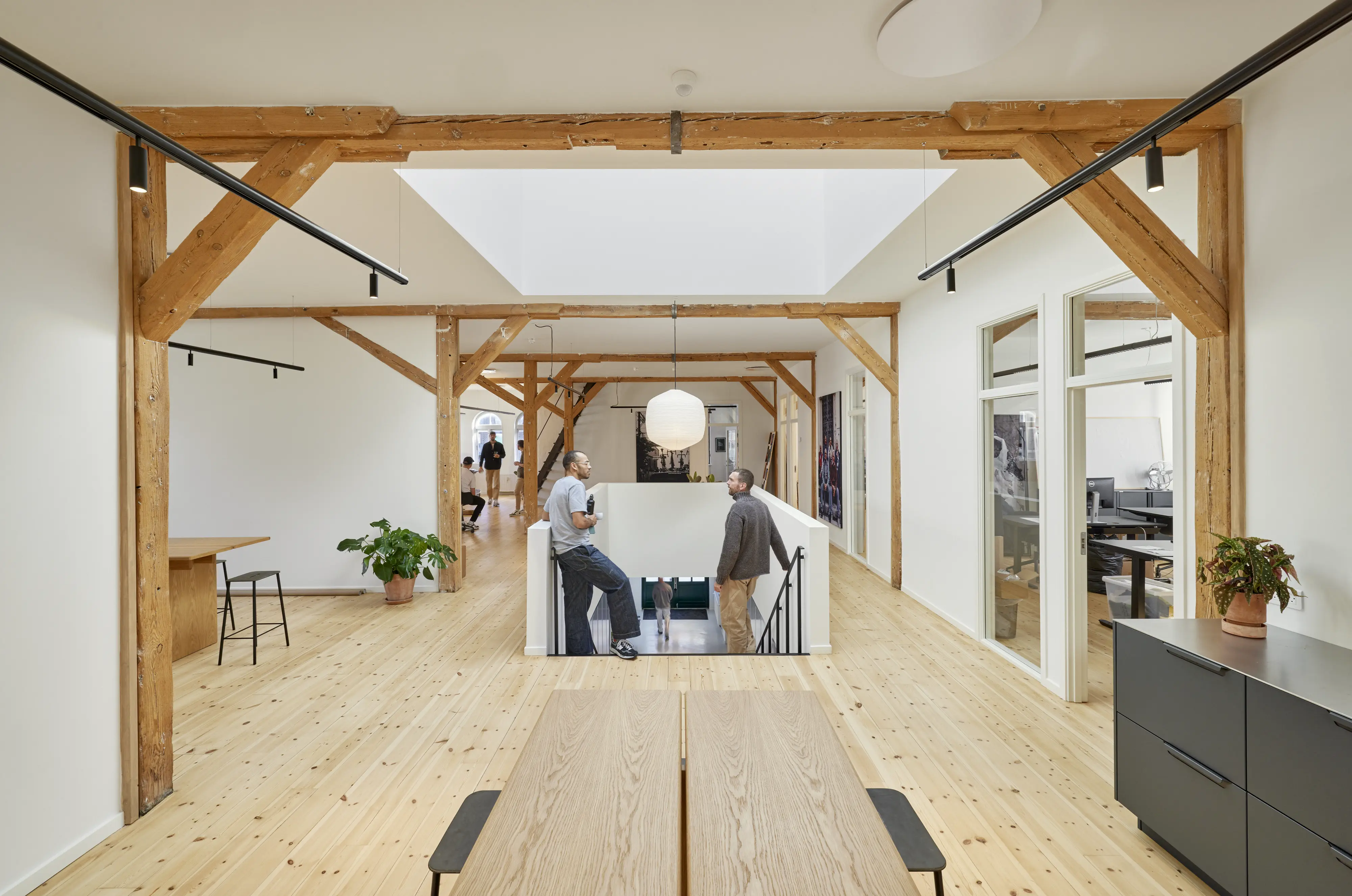 Kollegen unterhalten sich im Gemeinschaftsbereich ihres modernen Büros | VELUX Magazin